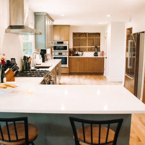 Light green kitchen with white quartz