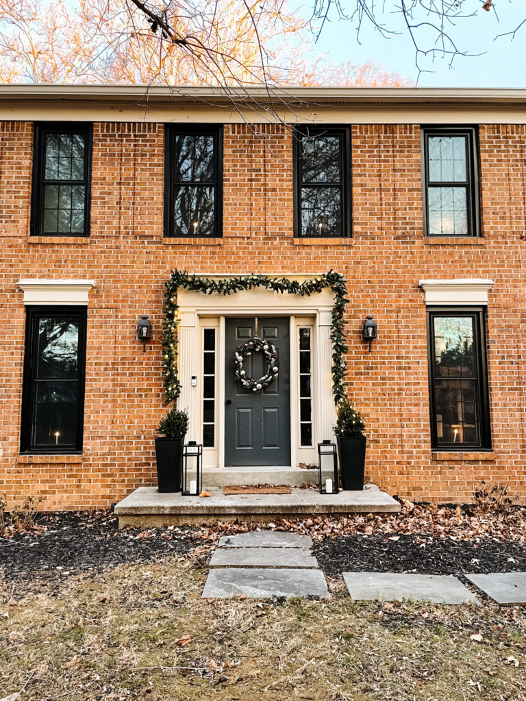  Christmas Garland with eucalyptus and pine cones on a brick house with black windows