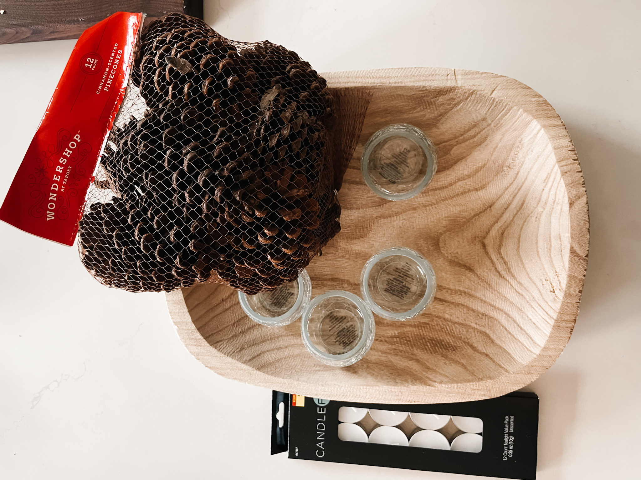 items needed for the christmas coffee table decor: a dough bowl, candles and pinecones