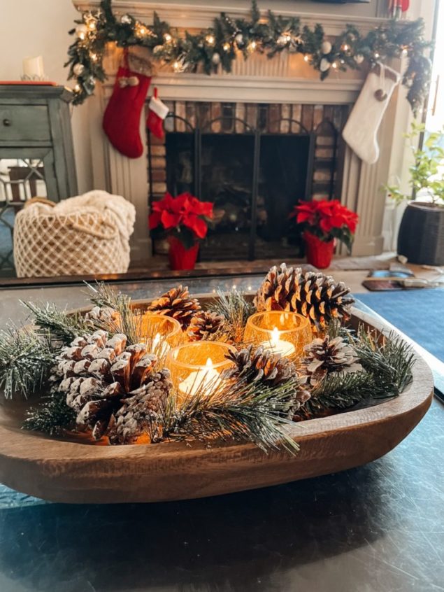 dough bowl filled with snowy pine cones, evergreen and candles