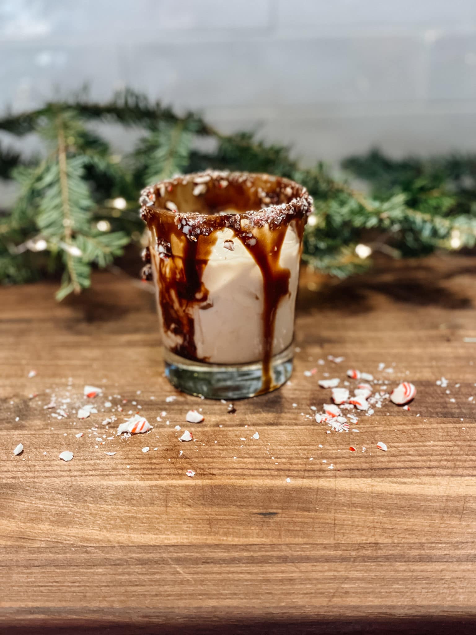 Glass of peppermint white russian cocktail with a chocolate and candy cane rim